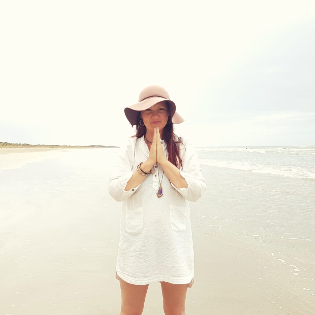 woman on beach with prayer hands